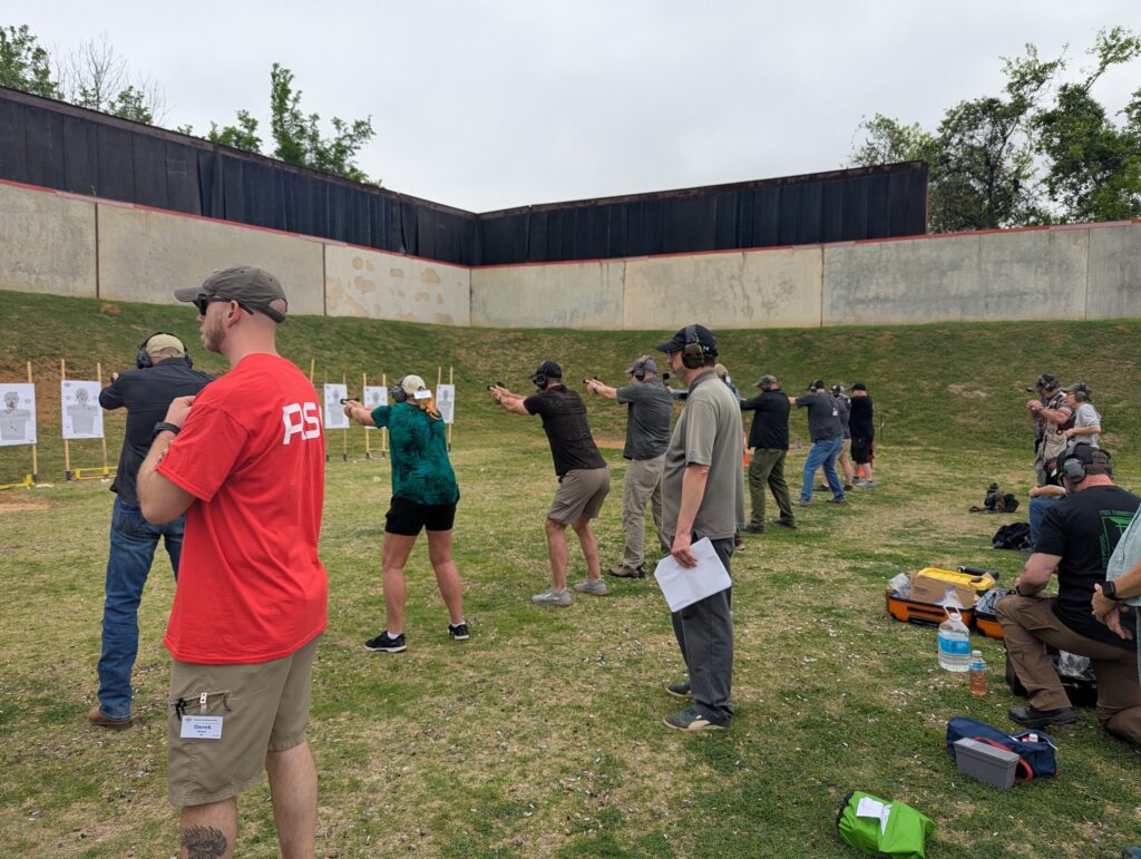 Students train self-defense tactics with pistols.
